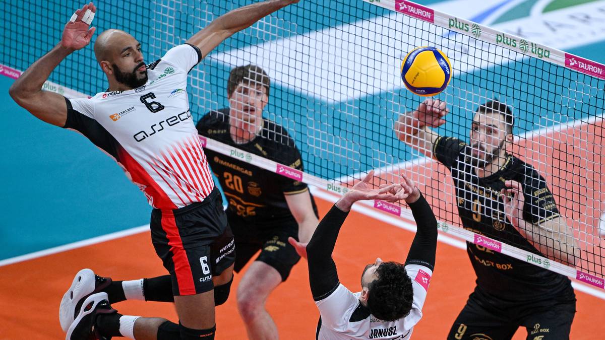 Siatkarz w białej koszulce z numerem 6 blokuje atak przeciwnika.