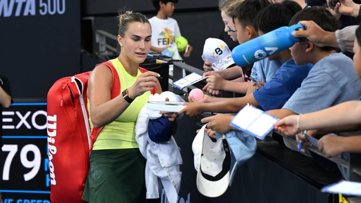 Aryna Sabalenka rozdaje autografy fanom po meczu.
