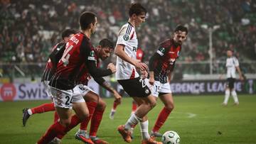 Piłkarze rywalizujący o piłkę na boisku podczas meczu.