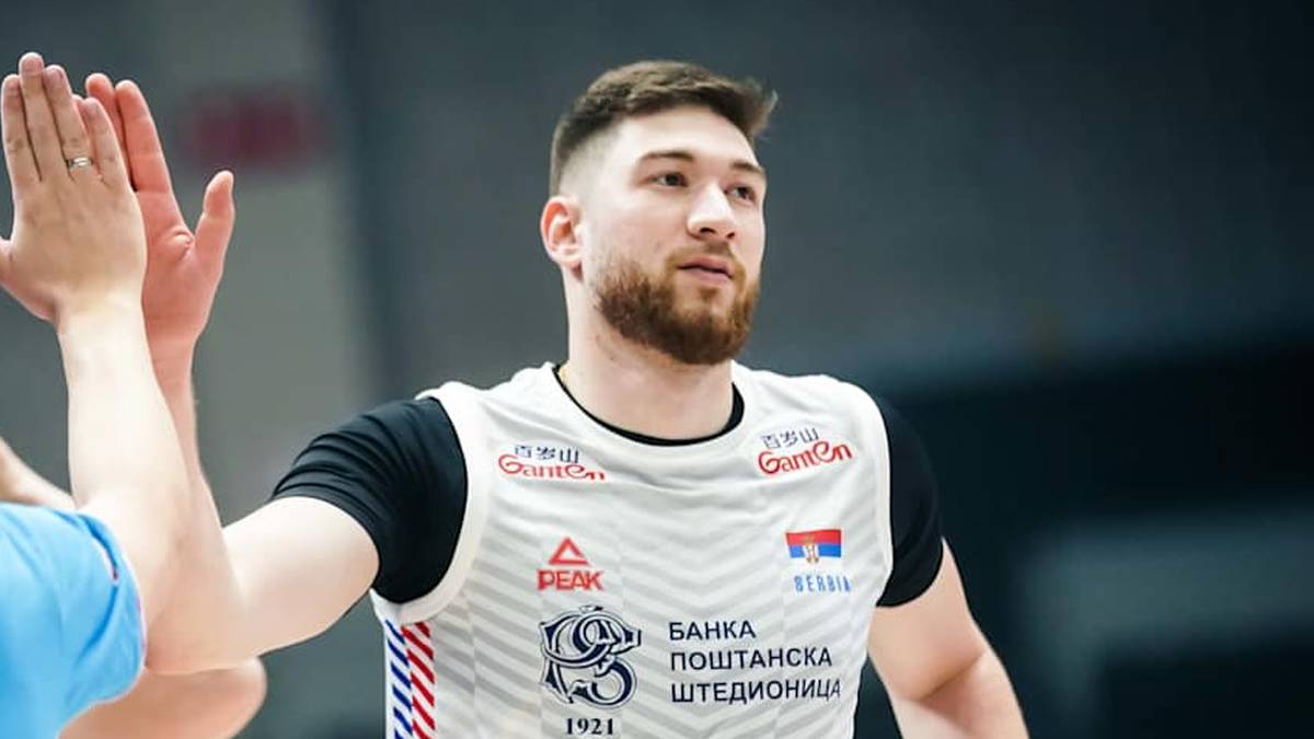 Dwóch siatkarzy wykonuje "piątkę", jeden z nich ma na koszulce numer 23 i napis "SERBIA".