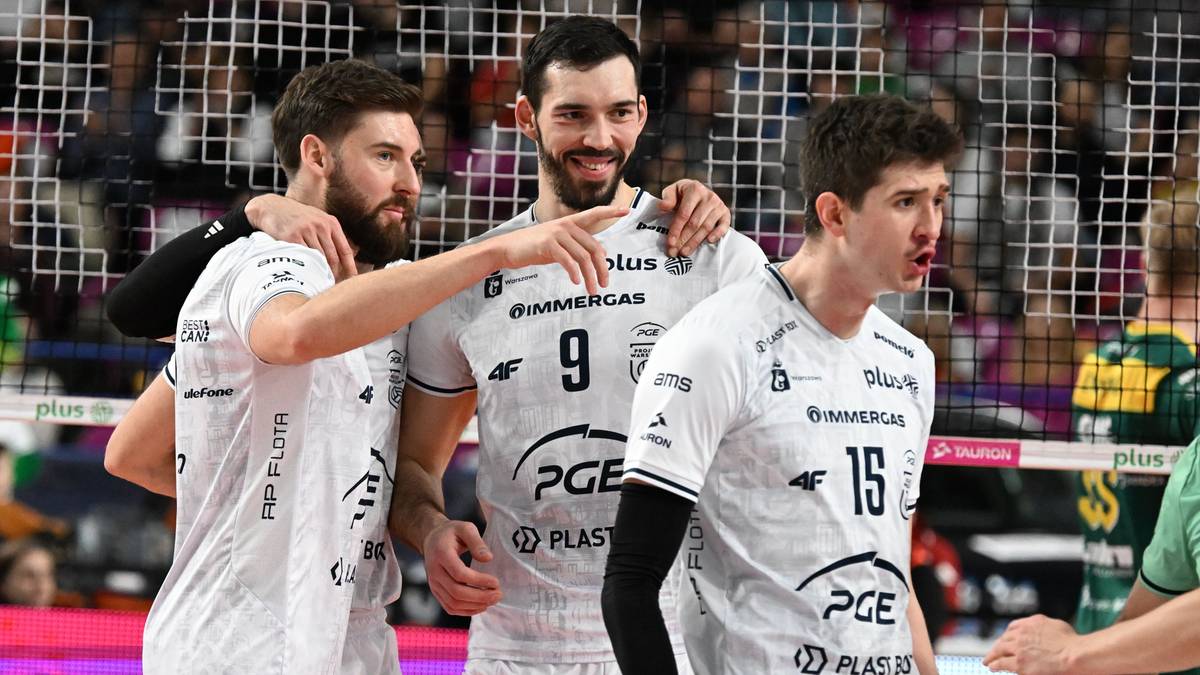 Trzech siatkarzy w białych koszulkach z nadrukami PGE Projektu Warszawa, jeden z nich wskazuje palcem.