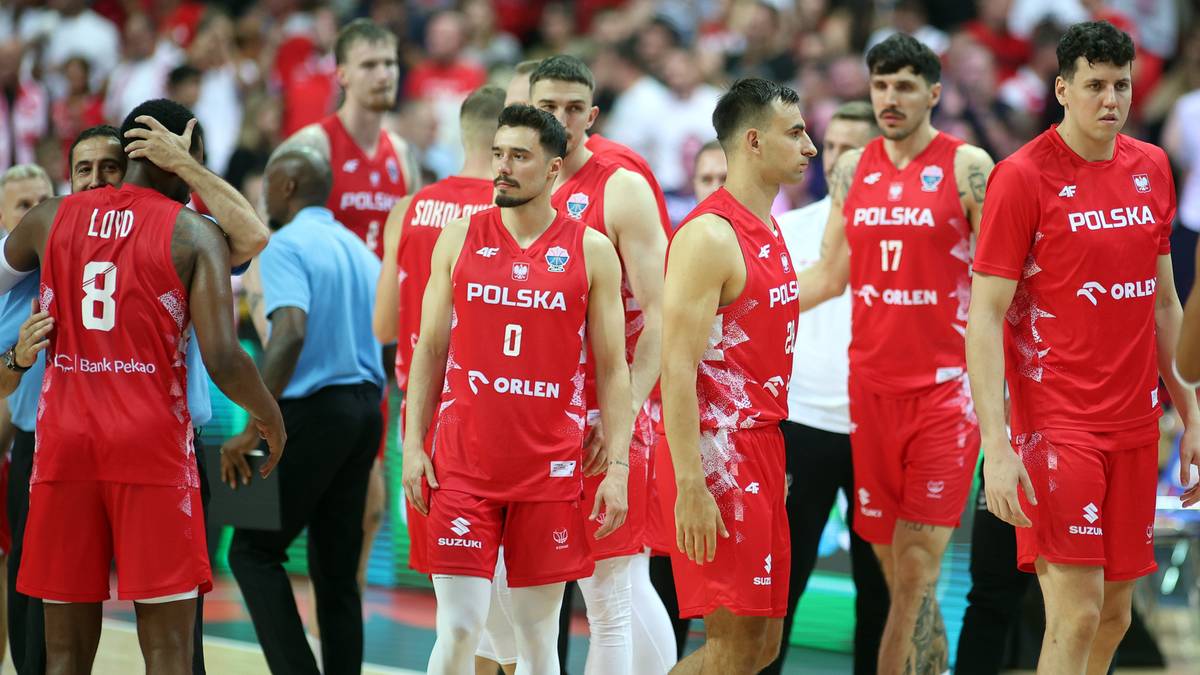 Drużyna koszykarzy w czerwonych strojach z napisem "Polska" stoi blisko siebie.