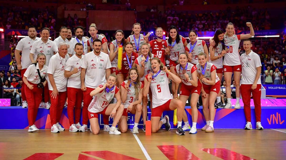 Drużyna siatkarek Polski pozuje do zdjęcia grupowego z pucharem i medalami po zwycięstwie w Lidze Narodów.
