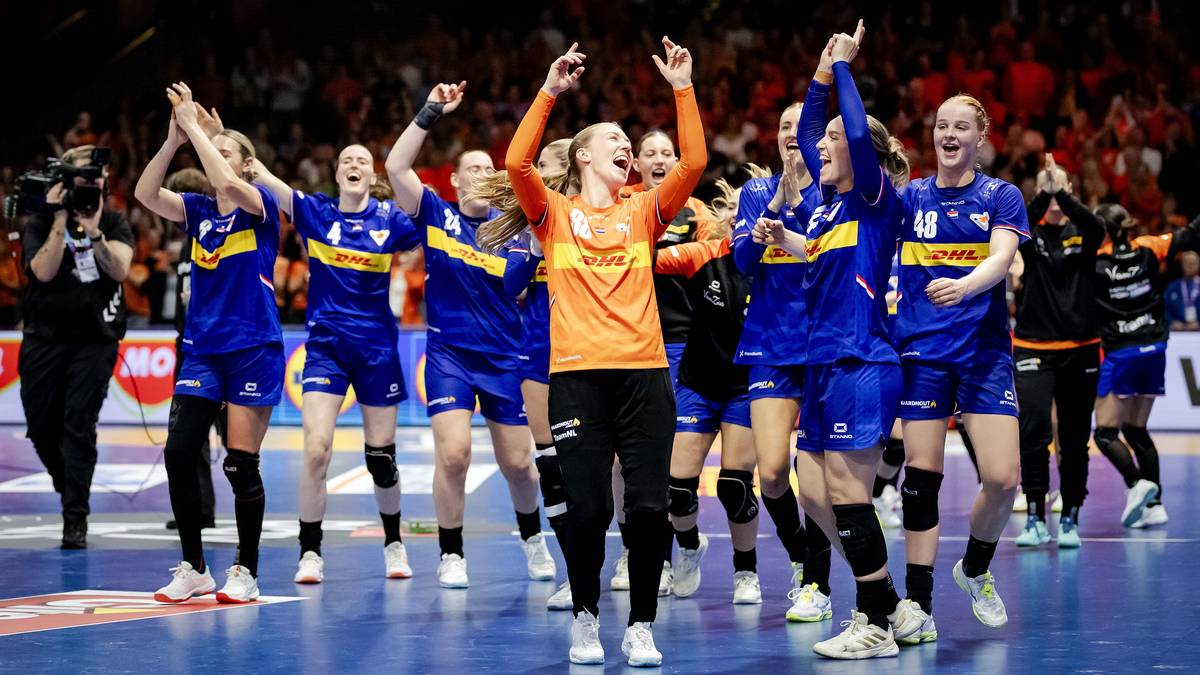 Drużyna piłki ręcznej kobiet świętuje zwycięstwo na boisku, zawodniczki w niebiesko-żółtych strojach podnoszą ręce do góry.
