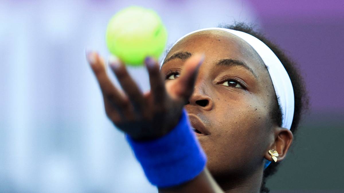 Tenisistka Coco Gauff z piłką tenisową w dłoni, przygotowująca się do serwisu.