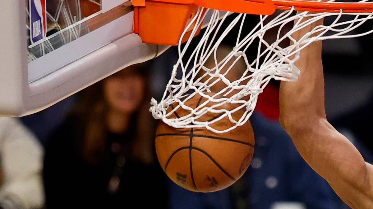 Piłka do koszykówki wpada do siatki kosza, zdobywając punkty.