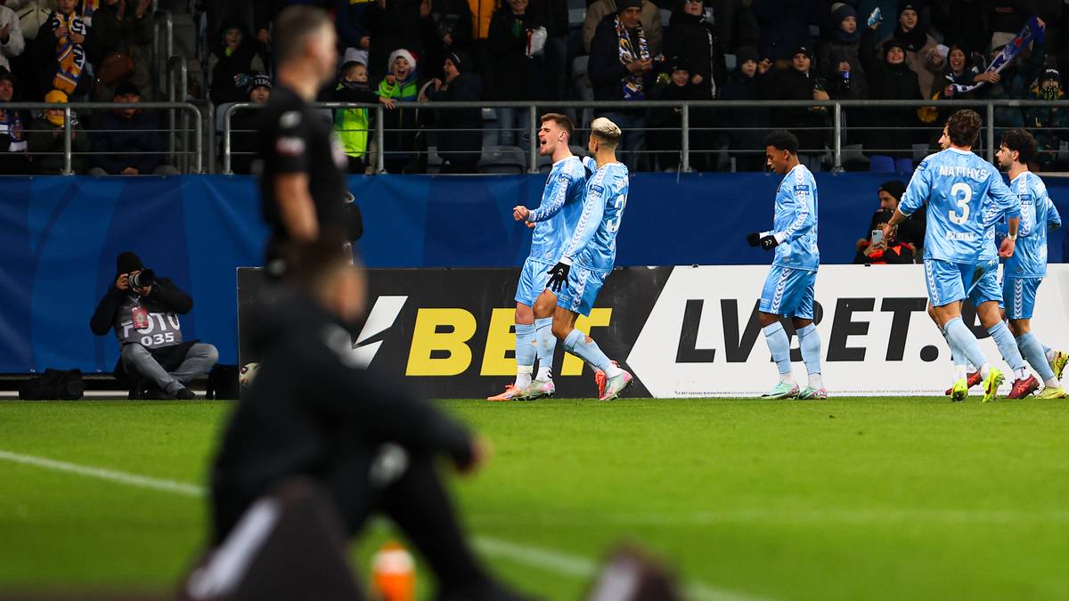 Piłkarze świętujący zdobycie bramki na zielonym boisku.