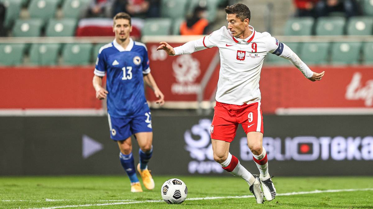 Piłkarz reprezentacji Polski Robert Lewandowski biegnie z piłką, w tle zawodnik Bośni i Hercegowiny