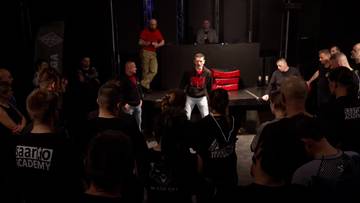 Grupa os&oacute;b na szkoleniu samoobrony Defendo, prowadzący szkolenie stoją przed uczestnikami.