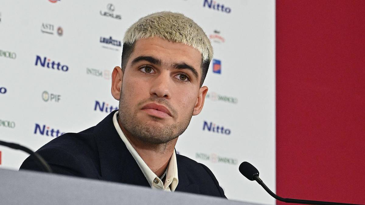 Carlos Alcaraz siedzi za stołem konferencyjnym z logo Nitto ATP Finals.