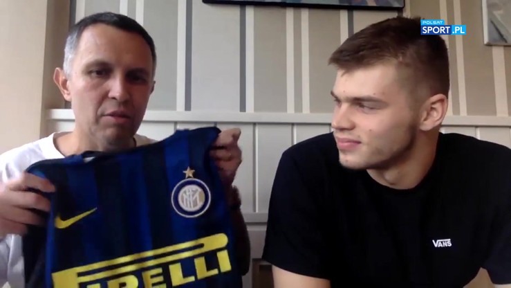 Mężczyzna pokazuje koszulkę Interu Mediolan, obok siedzi drugi mężczyzna.