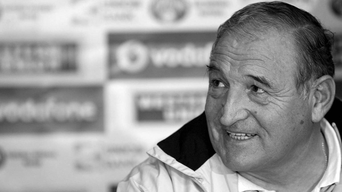 Portret czarno-biały starszego mężczyzny, prawdopodobnie piłkarza lub trenera, patrzącego w bok.