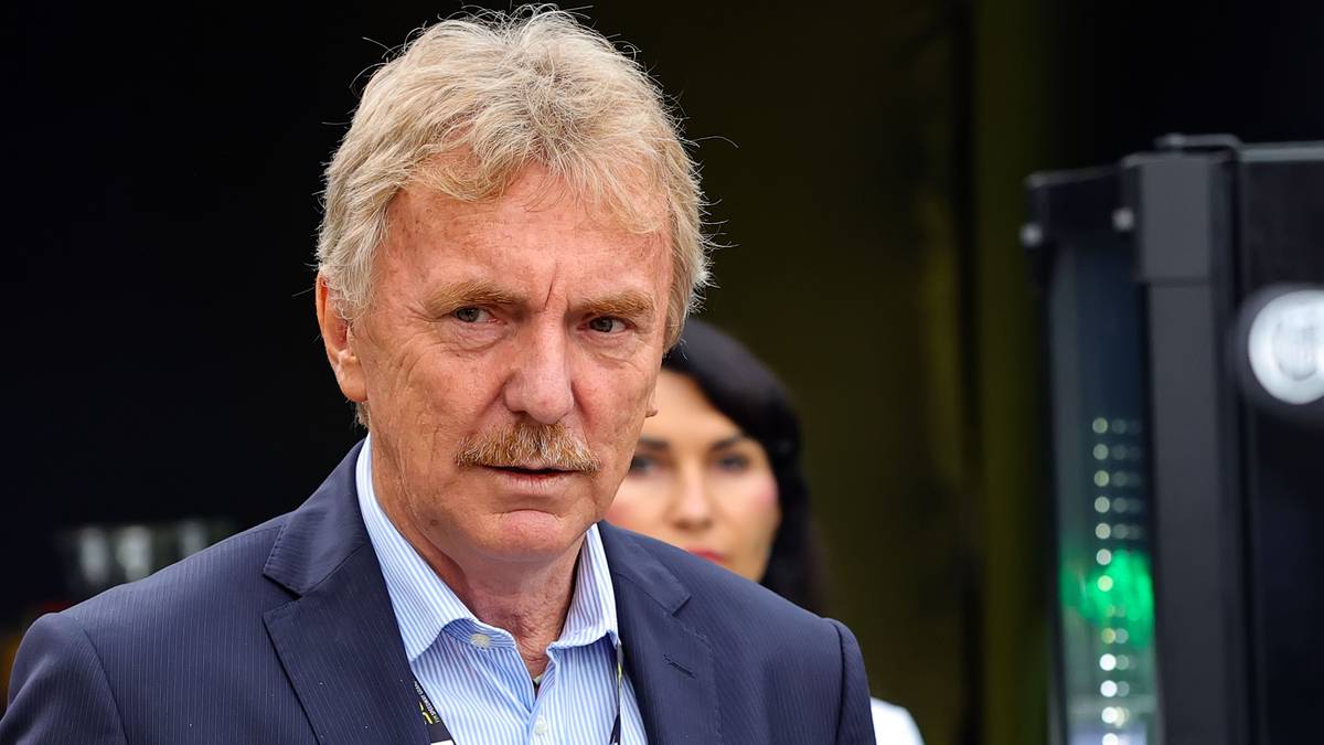 Zbigniew Boniek, mężczyzna w średnim wieku z siwiejącymi włosami i wąsami, ubrany w garnitur i jasną koszulę, patrzy w obiektyw z lekko zaniepokojoną miną.