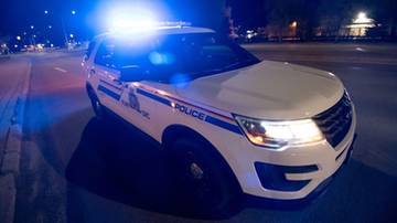 Radiow&oacute;z policyjny z zapalonymi niebieskimi sygnałami świetlnymi.