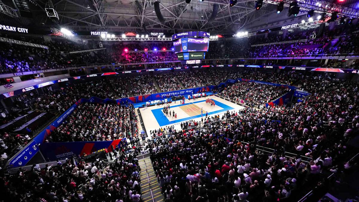 Widok z lotu ptaka na pełną hali widowiskową podczas meczu siatkówki. Na środku parkietu znajduje się boisko, a wokół niego zasiadają liczni kibice.