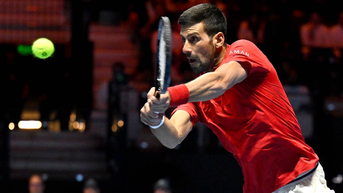 Novak Djoković w akcji, uderzający piłkę tenisową.