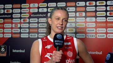Martyna Czyrniańska w czerwonej koszulce reprezentacji Polski udziela wywiadu przed ścianką sponsorską.