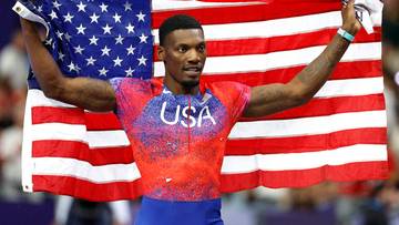 Fred Kerley, lekkoatleta, trzyma amerykańską flagę po zawodach.