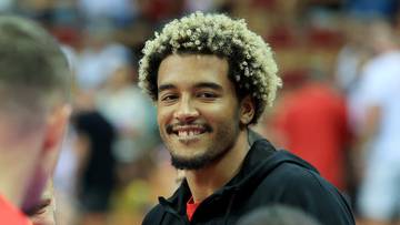 Trzech mężczyzn i jedna kobieta w strojach sportowych, dw&oacute;ch mężczyzn w czerwonych koszulkach z napisem Polska, jeden mężczyzna uśmiecha się.