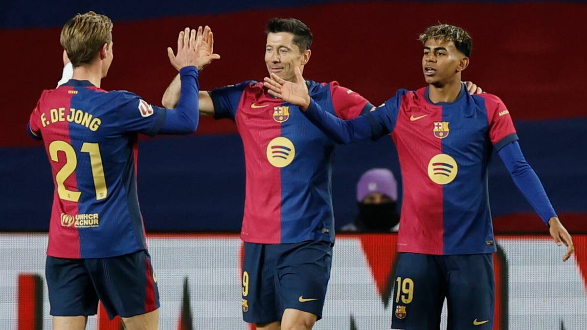 Trzech piłkarzy FC Barcelony w czerwono-niebieskich strojach świętuje gola, przybijając sobie piątki.