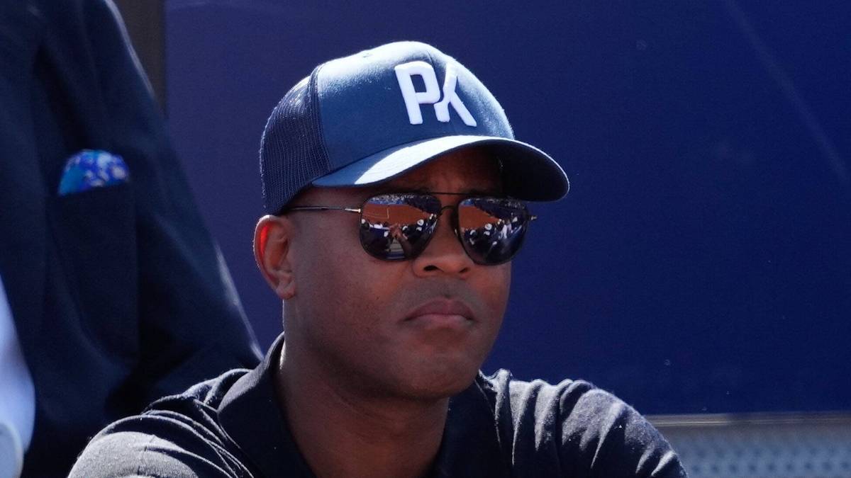 Mężczyzna w czapce z daszkiem z napisem "PA" i okularach przeciwsłonecznych.