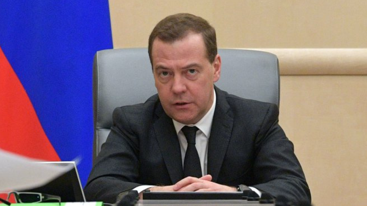 Dmitrij Miedwiediew siedzi przy biurku, patrząc w obiektyw.