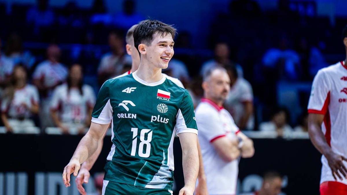 Siatkarz w zielonej koszulce z numerem 18, z biało-czerwoną flagą Polski na piersi.