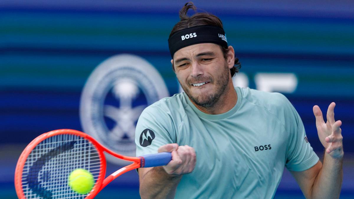 Tenisista Taylor Fritz podczas uderzenia piłki rakietą na korcie tenisowym.