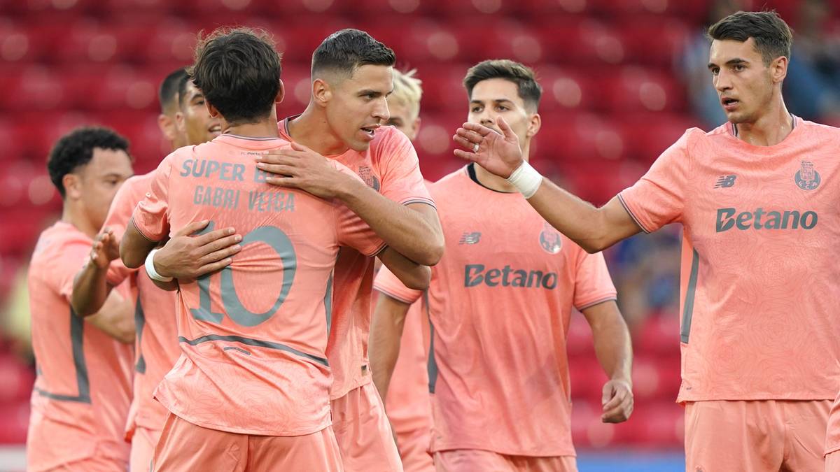 Grupa piłkarzy w różowych koszulkach świętuje gola. Jeden z nich, Jan Bednarek, jest w centrum, obejmując kolegę z drużyny. Na plecach jego koszulki widoczny jest napis "SUPER T" i numer 10.