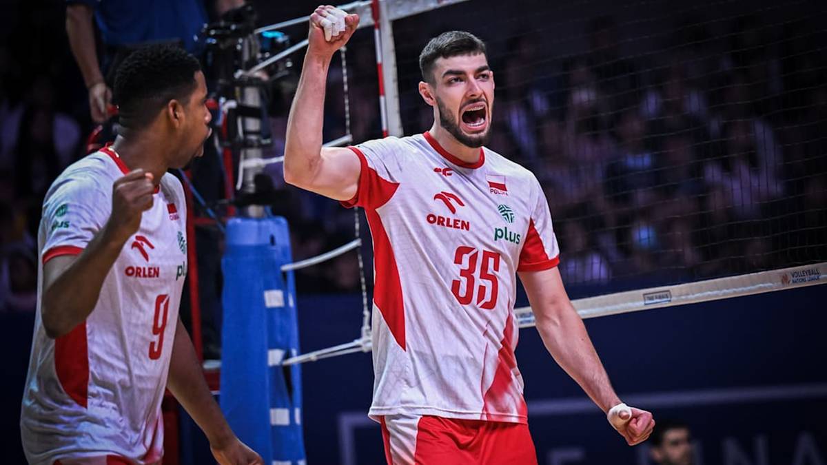 Siatkarz w białej koszulce z czerwonymi elementami, z numerem 35, krzyczy z radości, unosząc rękę. Obok niego inny siatkarz w podobnym stroju pokazuje zaciśniętą pięść.