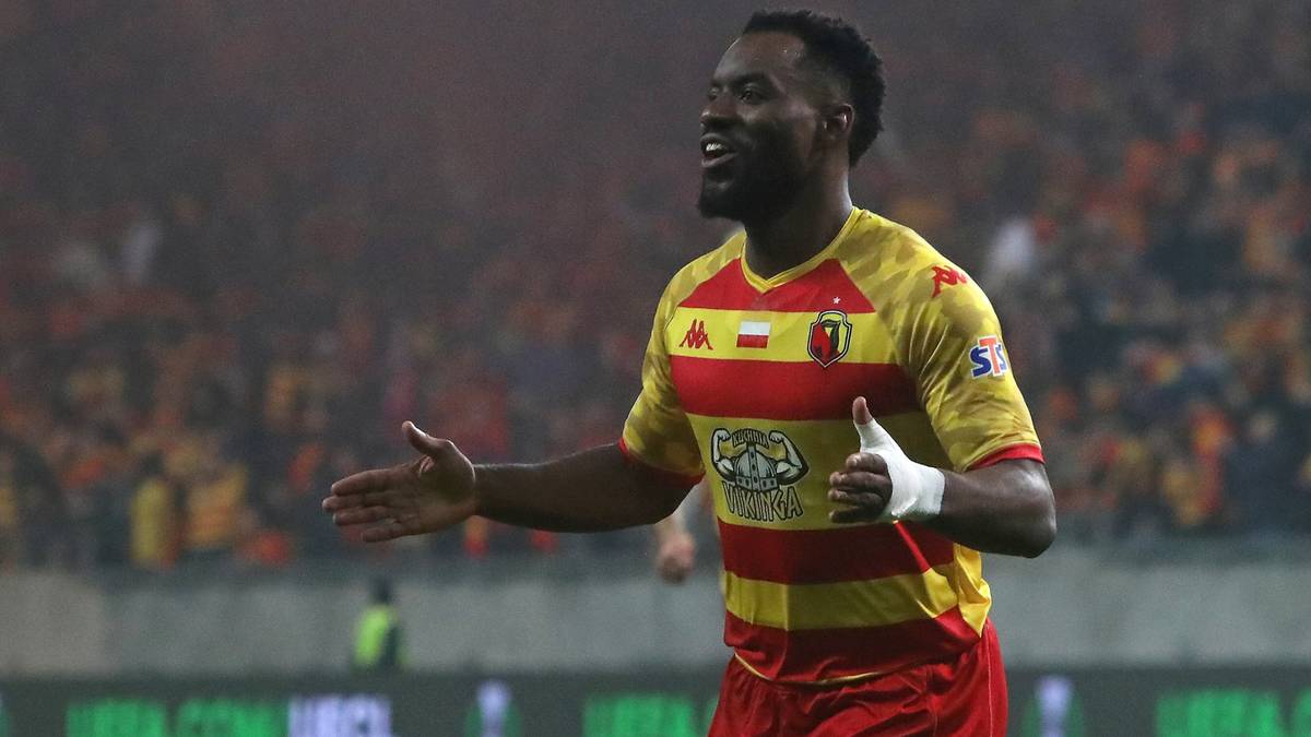 Piłkarz Jagiellonii w czerwono-żółtej koszulce z numerem 10 świętuje bramkę lub udaną akcję podczas meczu.