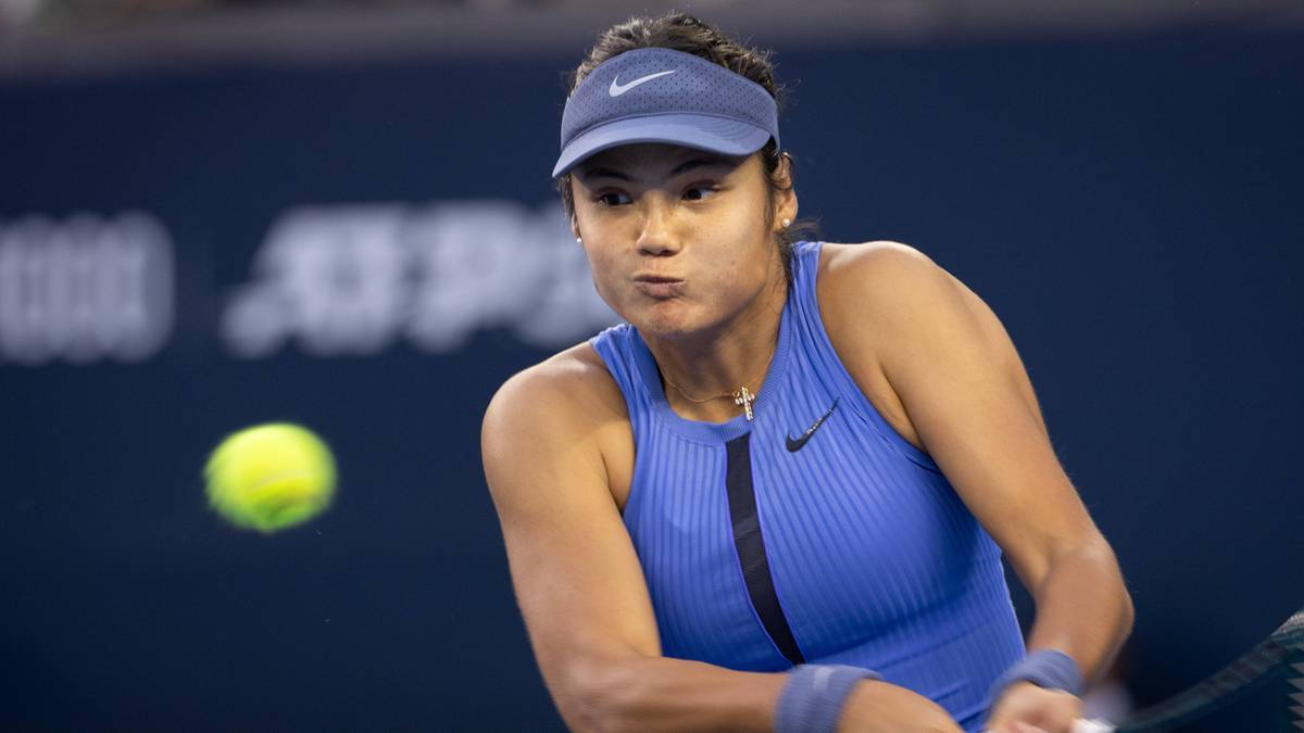 Tenisistka w niebieskim stroju sportowym odbija piłkę tenisową.