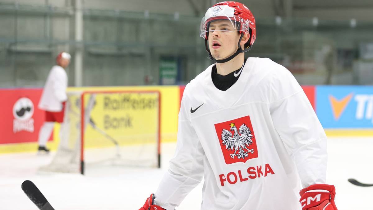 Hokeista reprezentacji Polski w białej koszulce z godłem i napisem Polska.