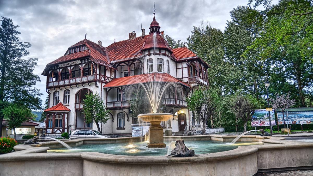 Architektura zabytkowego uzdrowiska z fontanną i otaczającą go zielenią