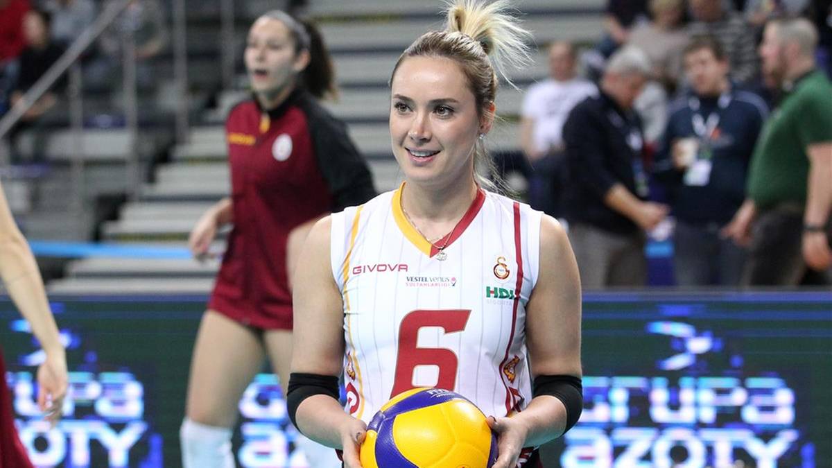 Siatkarka w białej koszulce z numerem 6 i ż&oacute;łto-niebieską piłką w rękach.