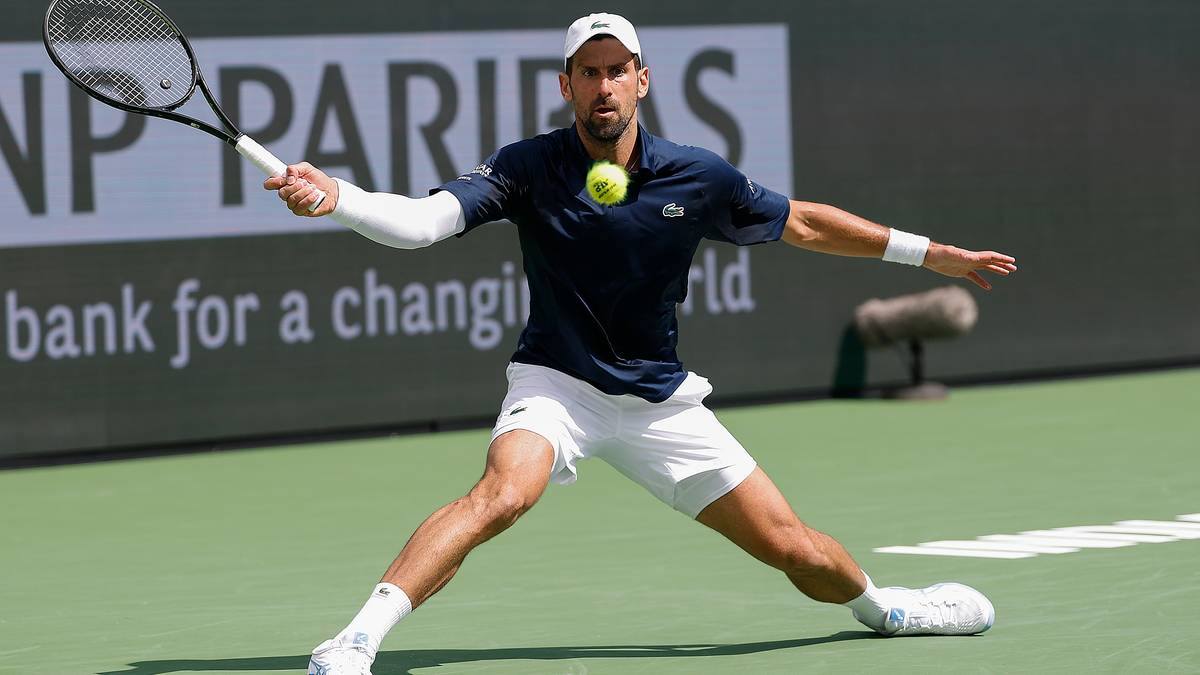 Novak Djoković podczas meczu tenisowego, wykonuje forhend.