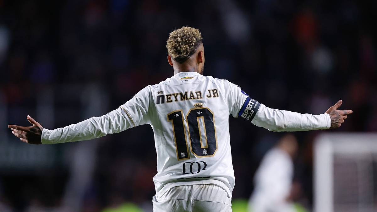 Piłkarz z numerem 10 na plecach, Neymar Jr., odwr&oacute;cony tyłem do widza, świętuje z rozłożonymi ramionami na boisku piłkarskim.