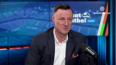 Tomasz Hajto w garniturze, siedzący przed mikrofonem i ekranem telewizyjnym w studio Polsat Sport, komentujący błąd bramkarza "Grabary".