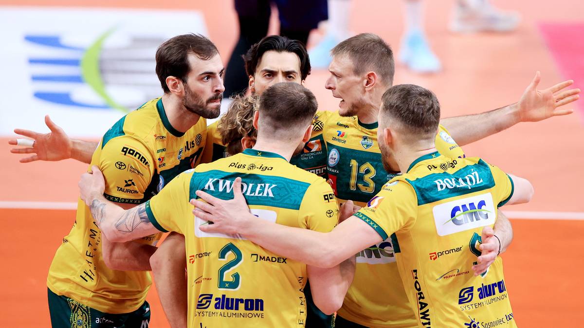 Drużyna siatkarzy w ż&oacute;łto-zielonych strojach celebruje na boisku.