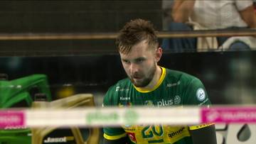 Siatkarz Mateusz Bieniek w zielonej koszulce z numerem 20, zamyślony, podczas meczu.