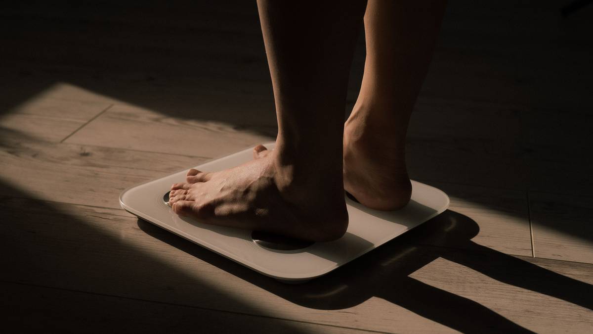 Stopy osoby stojącej na wadze łazienkowej.