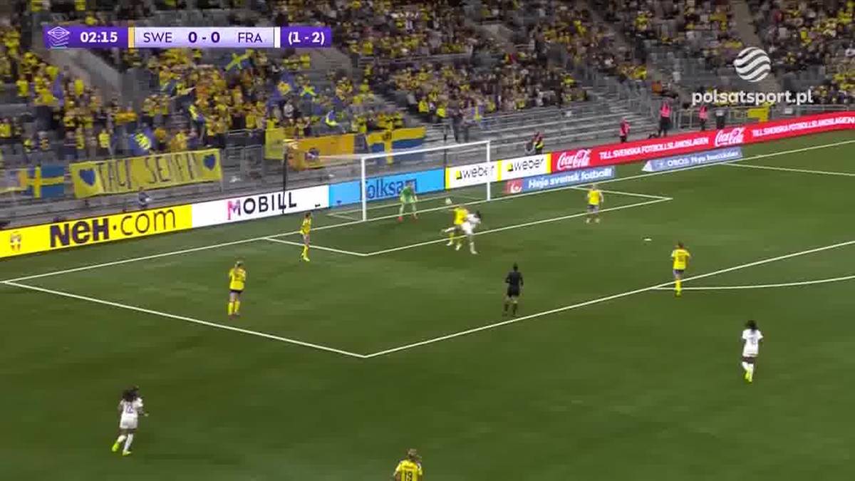 Boisko piłkarskie podczas meczu Szwecja - Francja, z widocznymi graczami w żółtych i białych strojach oraz kibicami na trybunach.