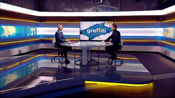 Dw&oacute;ch mężczyzn siedzi przy okrągłym stole w studiu telewizyjnym. Na ekranie za nimi widnieje logo programu "graffiti".