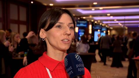 Anna Kiełbasińska, polska lekkoatletka, m&oacute;wi do mikrofonu podczas wywiadu. Ma na sobie czerwony sweter z golfem.