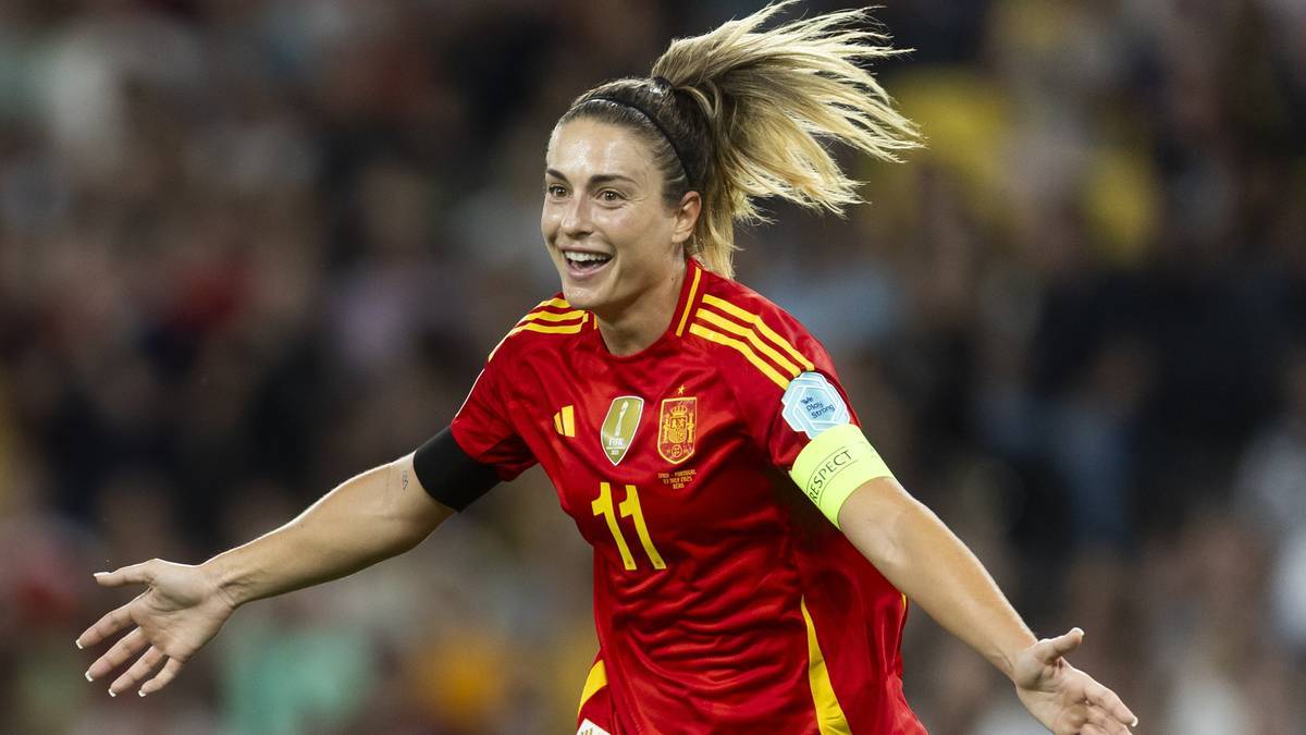 Piłkarka reprezentacji Hiszpanii w czerwonej koszulce z numerem 11 cieszy się ze zdobytej bramki, z rozłożonymi rękami i uśmiechem na twarzy.