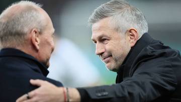 Dw&oacute;ch mężczyzn, prawdopodobnie trener&oacute;w piłkarskich, rozmawia ze sobą.