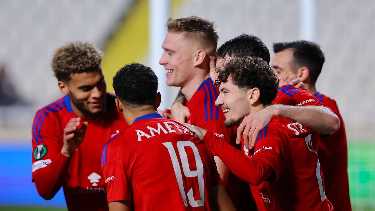 Piłkarze w czerwonych strojach świętują bramkę, jeden z nich ma na plecach numer 19.