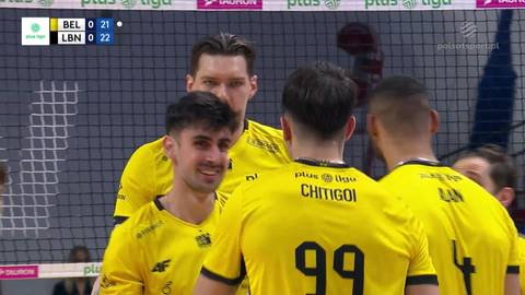 Gracze w ż&oacute;łtych koszulkach z numerami na plecach dyskutują podczas meczu siatk&oacute;wki.