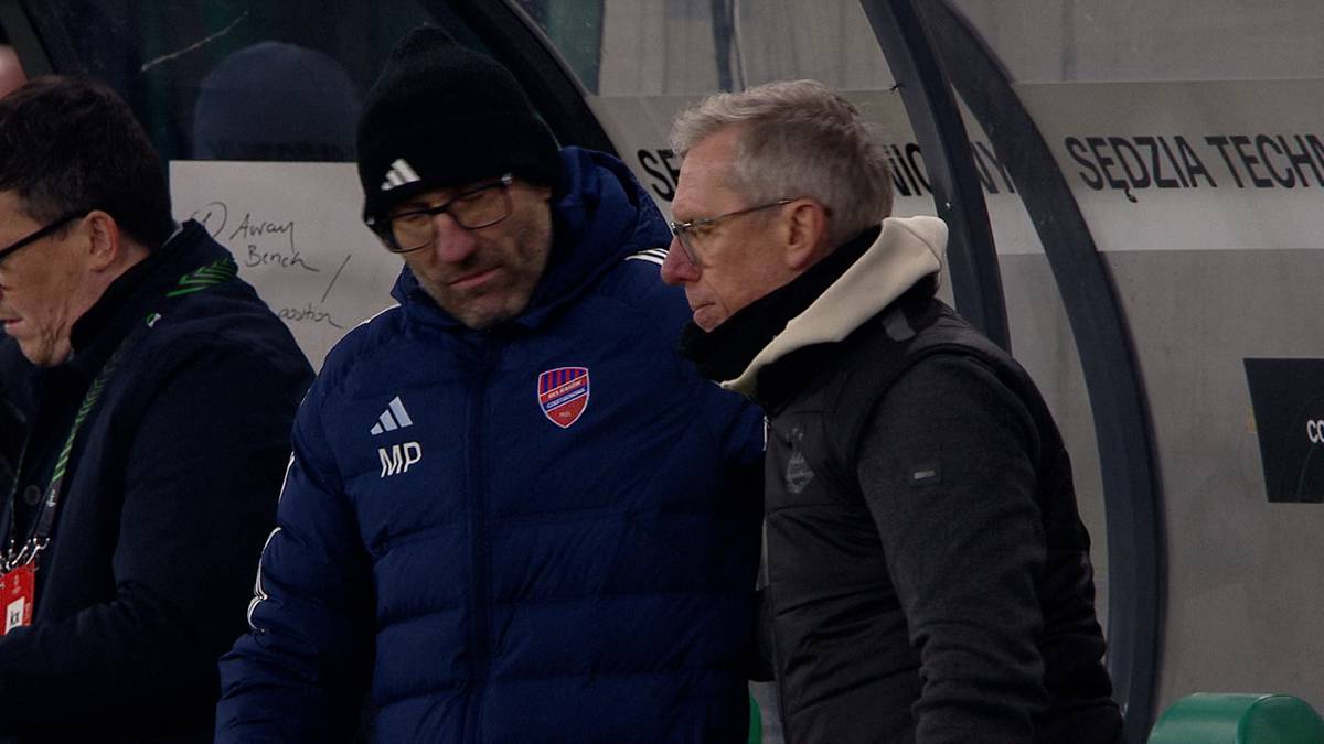 Dwóch mężczyzn w strojach sportowych rozmawia, jeden z nich ma rękę na ramieniu drugiego.