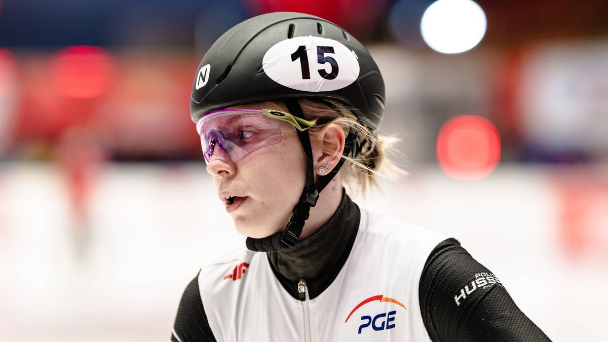 Portret łyżwiarki szybkiej na kr&oacute;tkim torze w kasku i okularach ochronnych.